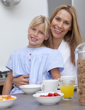 Smiling mother and daughter having breakfast togetherの写真素材