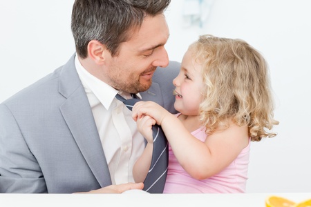 Little girl adjusting the tie of his fatherの写真素材
