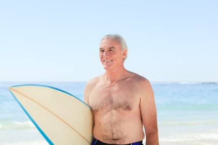 Retired  man with his surfboardの写真素材