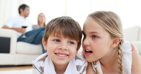 Little girl telling a secret to her brotherの写真素材