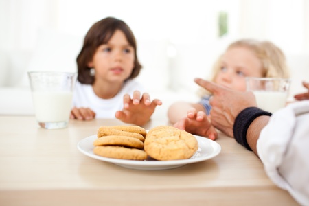 Siblings eatings biscuits and drinking milk の写真素材