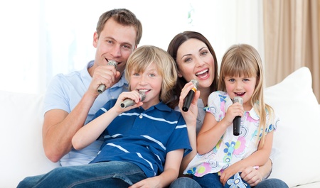 Happy family singing a karaoke together Happy family singing a karaoke together
