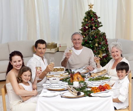 Family tusting with white wine in a Christmas dinnerの写真素材