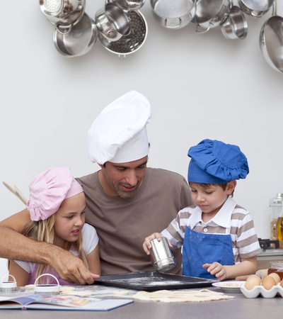 Father baking cookies with his childrenの写真素材