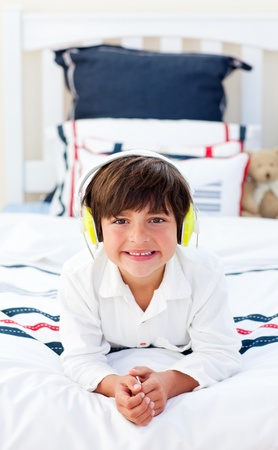 Smiling little boy listening music with headphones onの写真素材