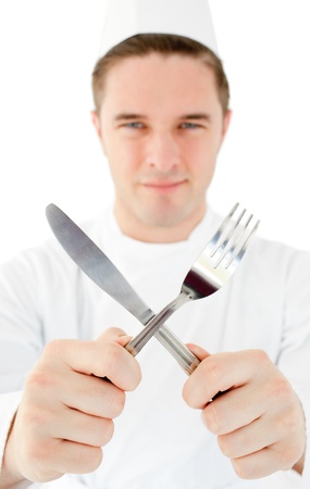 Handsome cook holding cutleryの写真素材