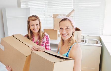 Bright female friends holding boxes の写真素材