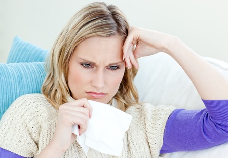 Diseased woman lying on a sofa with tissues Diseased woman lying on a sofa with tissues