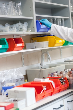 Close-up of a scientist taking something on the shelf