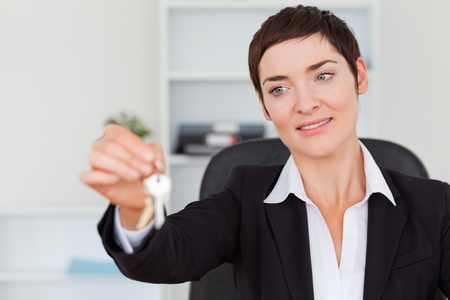 Secretary showing keys in her officeの写真素材