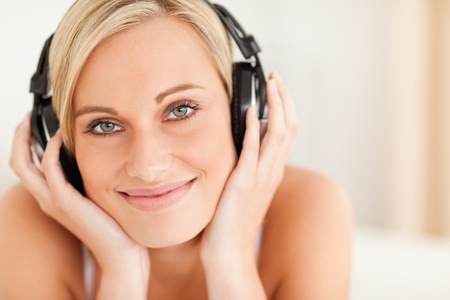 Close up of a woman wearing headphones in her bedroomの写真素材