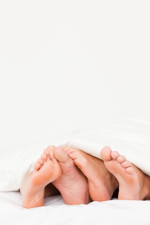 Portrait of four feet in a bedの写真素材