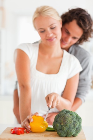 Portrait of a young couple slicing pepper with the camera focus on the vegetablesの写真素材
