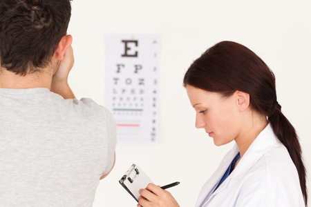 A female optician and a patient using an eye test