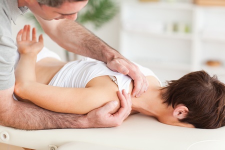 Gorgeous brunette woman getting a shoulder-massage in a roomの写真素材