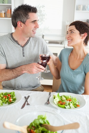 Close up of a Happy couple toasting with redwine in a dining roomの写真素材