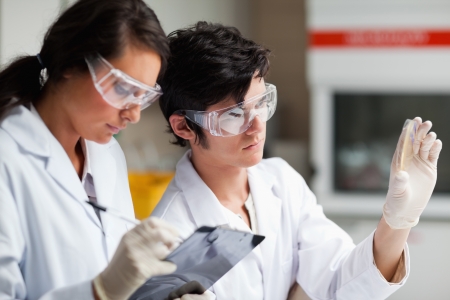 Concentrate science students looking at Petri dish in a laboratoryの写真素材