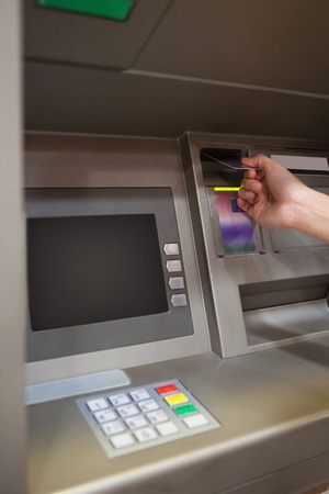 Portrait of a hand inserting a credit card in an ATMの写真素材