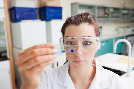 Cute science student looking at a microscope slide in a laboratory
