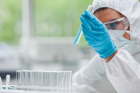 Protected science student holding a test tube in a laboratory