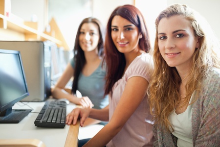 Fellow students posing with a computer in with the camera focus on the foreground modelの写真素材