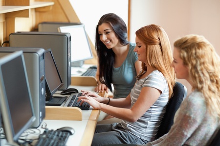 Smiling students working together in an IT room