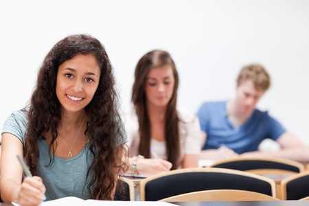 Smiling young students sitting in a classroomの写真素材