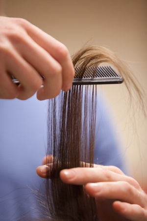 Close up of a hand combing hair with a combの写真素材