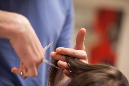 Close up of a masculine hand cutting hair with scissorsの写真素材