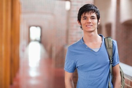 Smiling male student posing in a corridorの写真素材