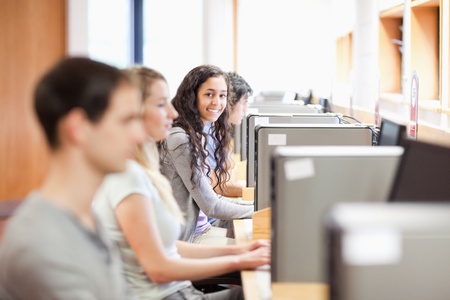 Fellow students in an IT room with the camera focus on the backgroundの写真素材