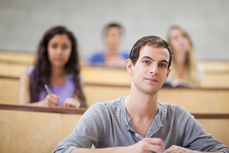 Young students listening during a lecture with the camera focus on the foregroundの写真素材