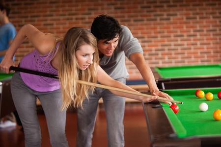 Young couple playing snooker in a home student
