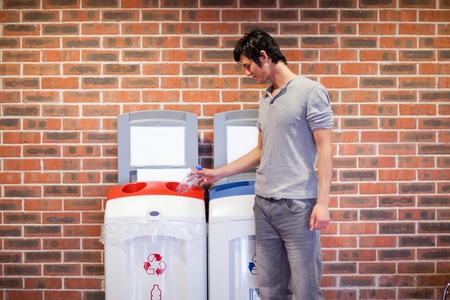 Young man recycling a plastic bottleの写真素材