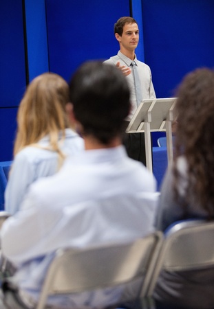 Portrait of a young man doing a presentation to business peopleの写真素材