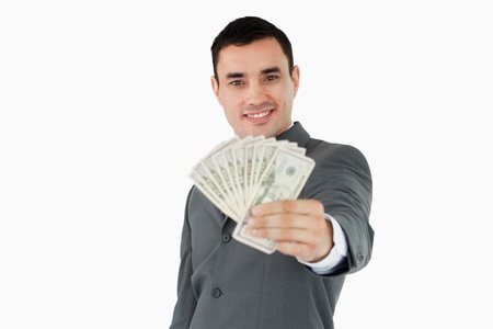 Smiling businessman presenting bank notes against a white backgroundの写真素材