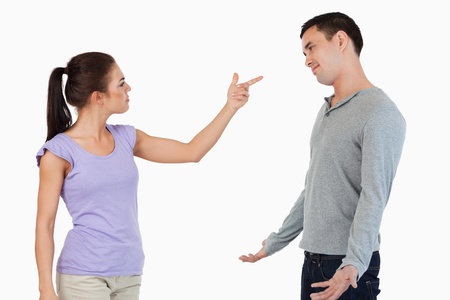 Young female blaming her boyfriend against a white background