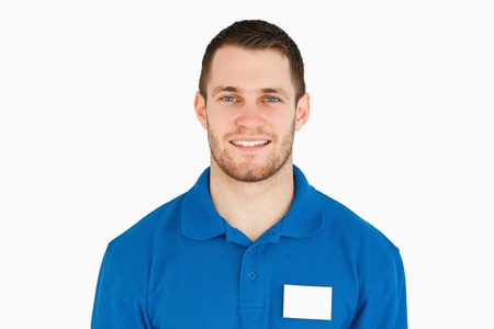 Smiling young sales assistant against a white background