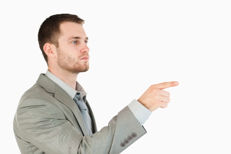 Side view of young businessman using futuristic touchscreen against a white backgroundの写真素材
