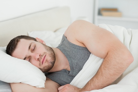 Handsome man sleeping in his bedroomの写真素材