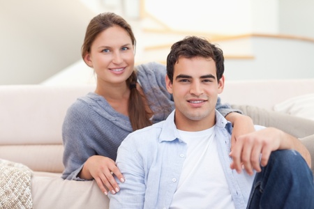 Couple sitting in their living room while looking at the cameraの写真素材
