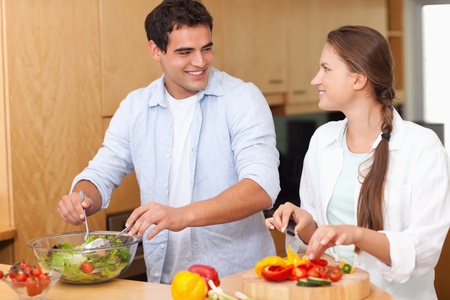 Couple preparing a salad in their kitchenの写真素材
