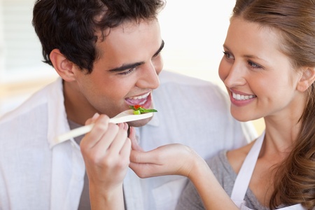 Happy smiling couple enjoys cooking togetherの写真素材