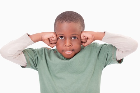 Boy with the fists on his face against a white backgroundの写真素材