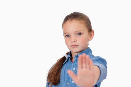 Girl saying stop with her hand against a white background