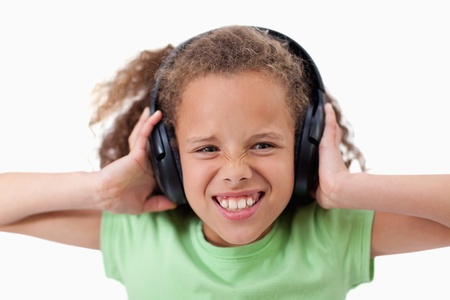 Cute girl listening to music against a white backgroundの写真素材