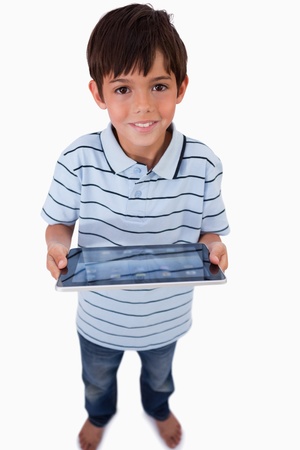 Portrait of a happy boy using a tablet computer against a white backgroundの写真素材