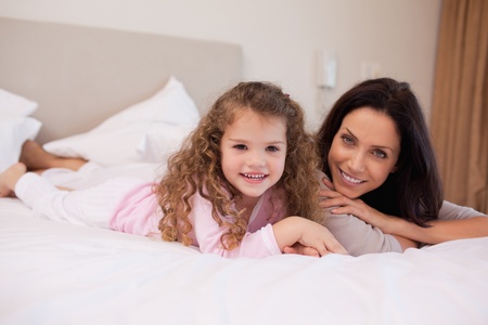 Young mother and daughter relaxing in the bedroom togetherの写真素材