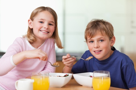 Children having breakfast in a kitchenの写真素材