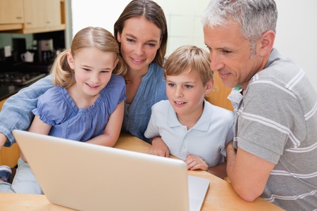 Lovely family using a laptop in their kitchen